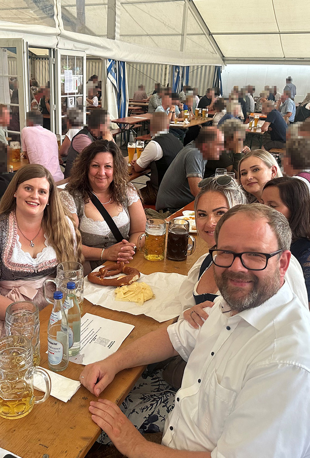 Mitarbeiter lachen gemeinsam am Biertisch beim Schöllnacher Volksfest